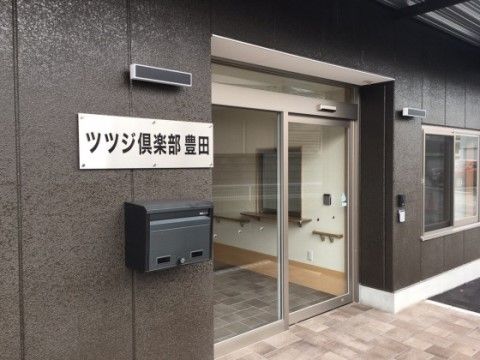 バリアフリー仕様のエントランスがある、ダークな色調で落ち着いた印象の外観の建物