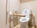 トイレには、安全に考慮して複数の手すりや、緊急時用のコールボタンが設置されている。床には緑色のマットが敷いてある。