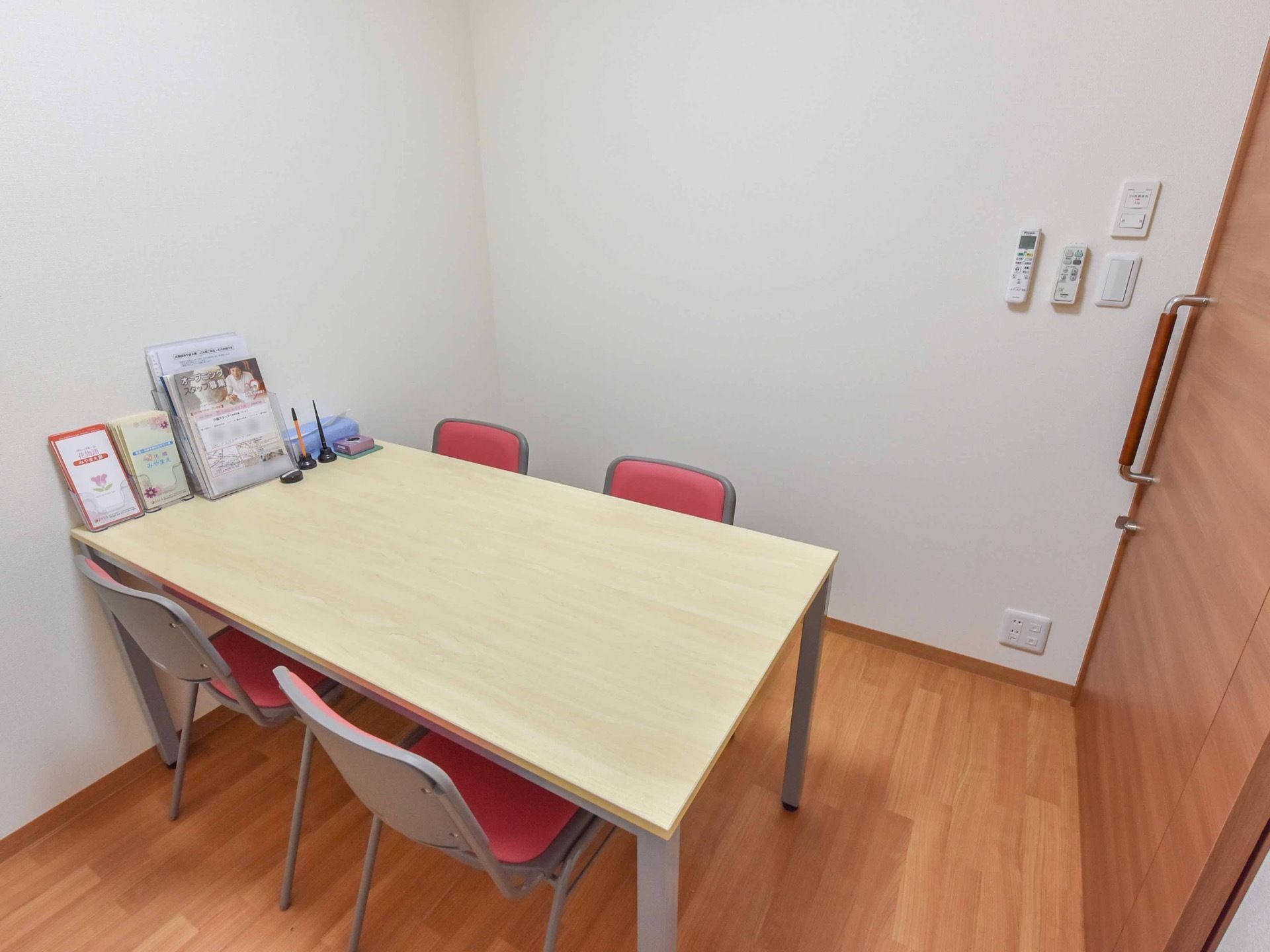 こぢんまりとした部屋にテーブルと椅子が４脚置かれている。各種パンフレットや筆記用具がテーブル上に並べられている。