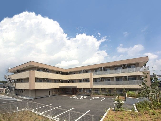 広い駐車スペースがある、L字型をした四角い外観の建物