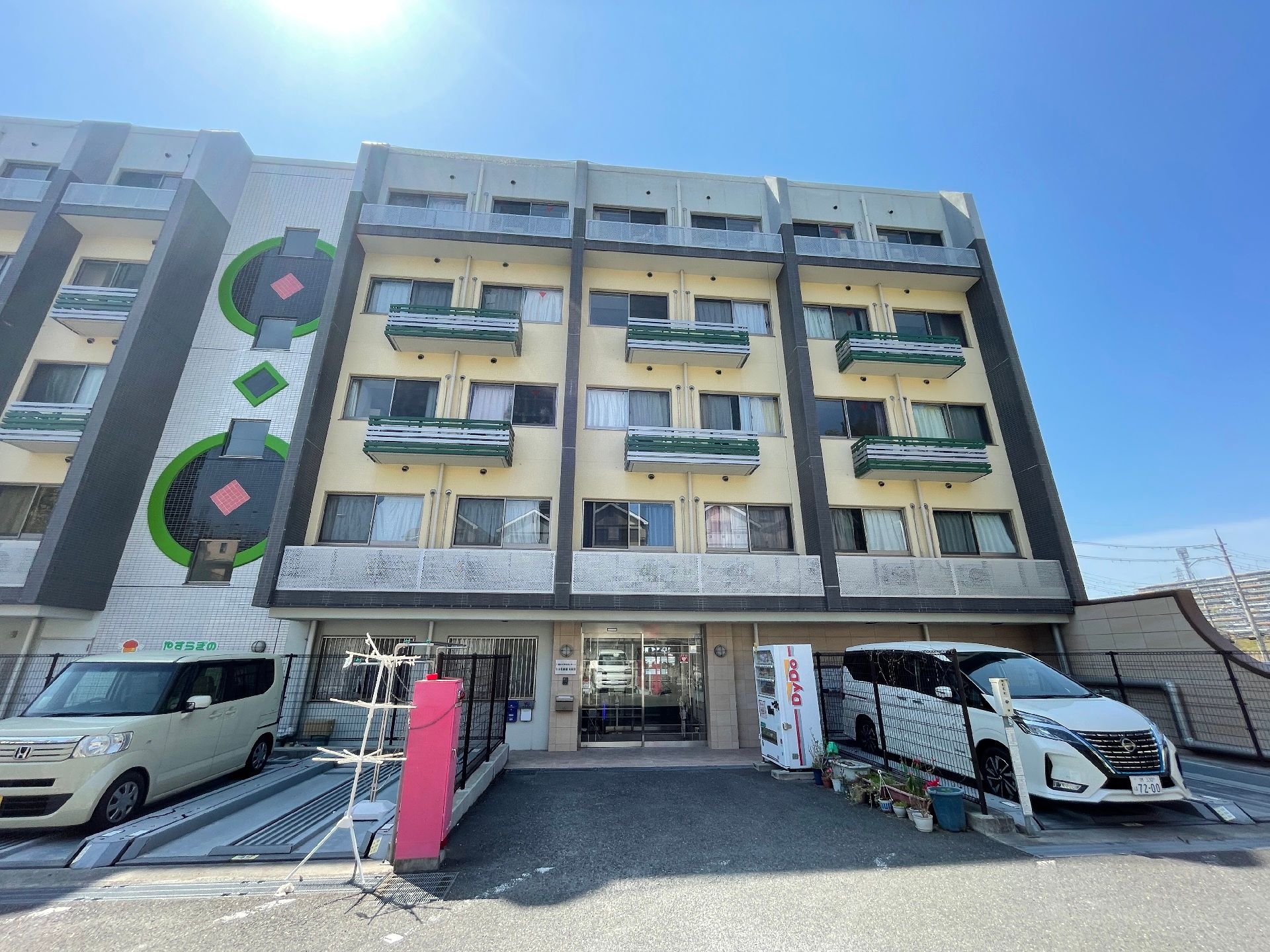 日当たりのいい場所に建っている建物はベージュとグレーで窓がたくさんついている。