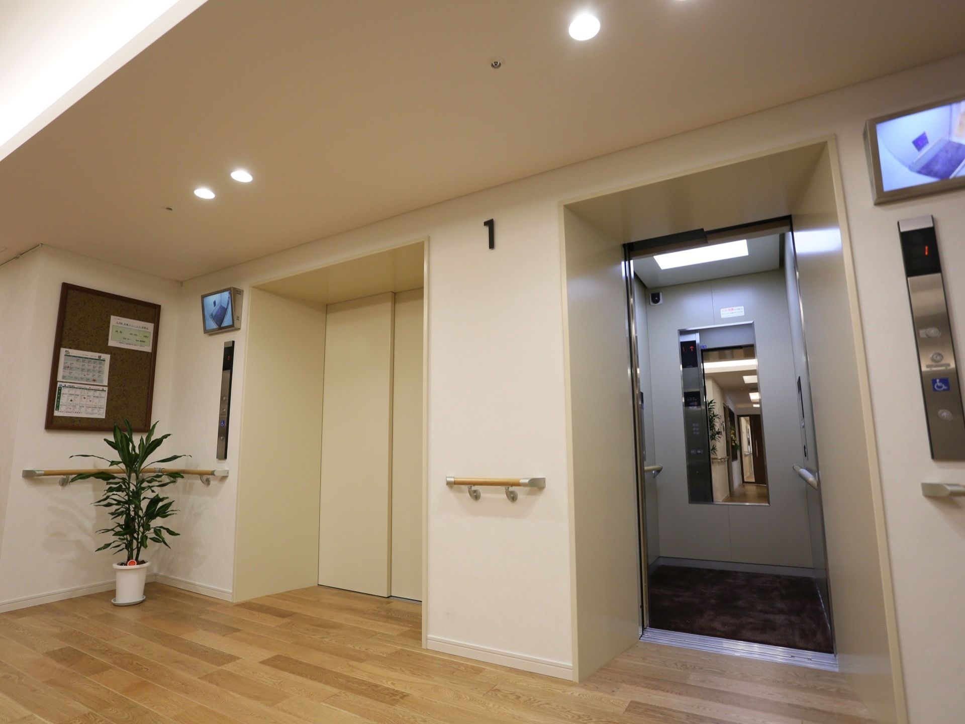 通路のくぼんだ所にエレベーターが2基並んで設置されている。エレベーターの扉は通路の壁と同系色である。呼び出しボタンがそれぞれの扉の横にある。