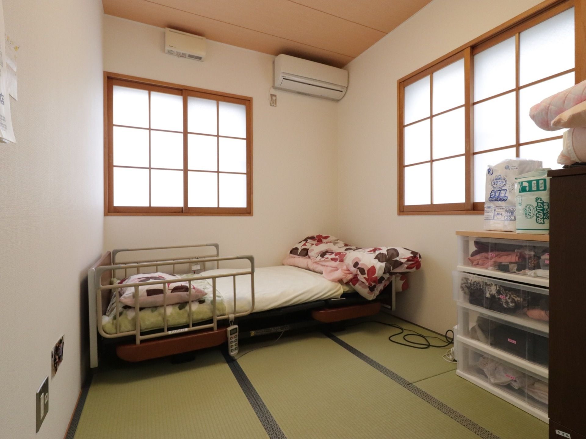 施設では畳敷きの居室を用意し、室内には介護ベッドとチェストを配置している。壁の上部にエアコンを設置している。