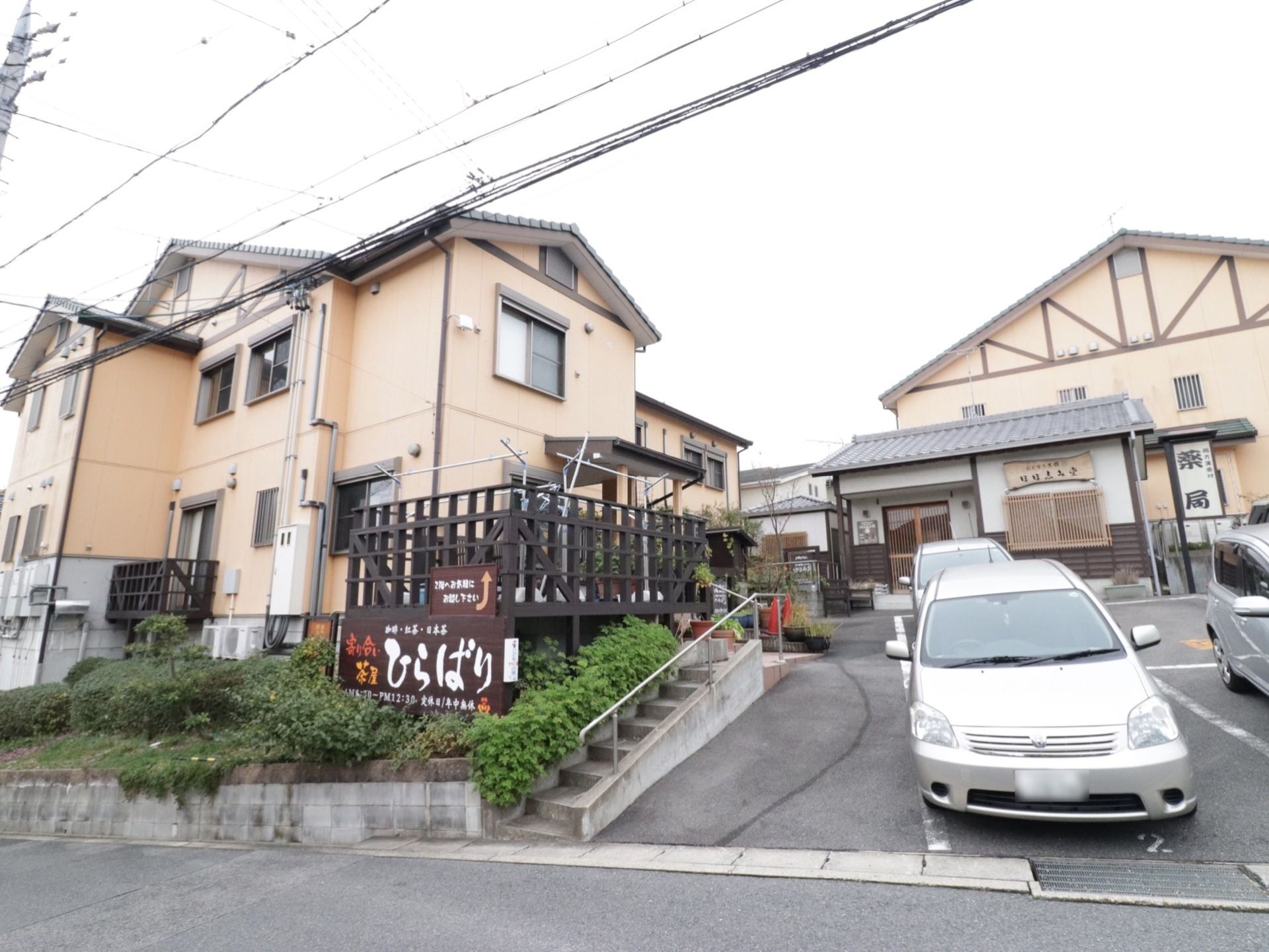 施設の建物は二階建てで、道路から少し高い位置に建っている。入り口から玄関まで手すり付きのステップを設置している。