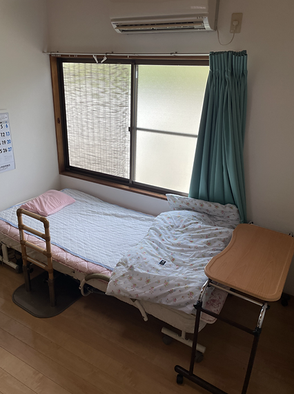 器具を引っ張りリハビリをする高齢女性と理学療法士の男性