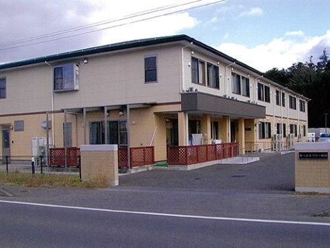 広い駐車場が併設している、明るい色合いの２階建ての施設