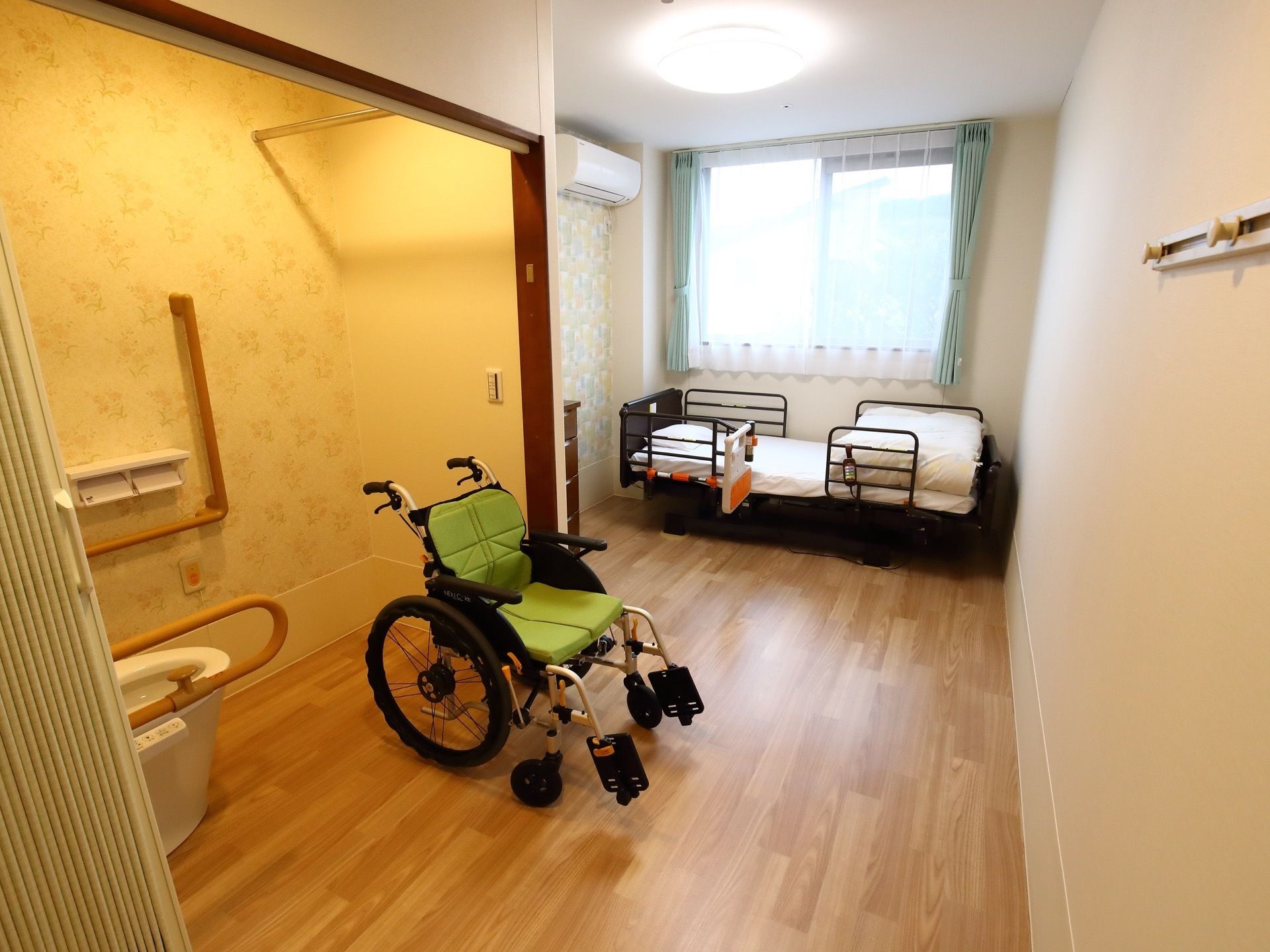 居室内のトイレの壁にL字型の手すりや、可動式の手すりがついており、車椅子からの移動がしやすい設計になっている。