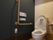 居室の中にあるトイレである。温水洗浄便座や手すり、緊急呼出ボタンなどが備わっており、個室の上部には棚も用意されている。