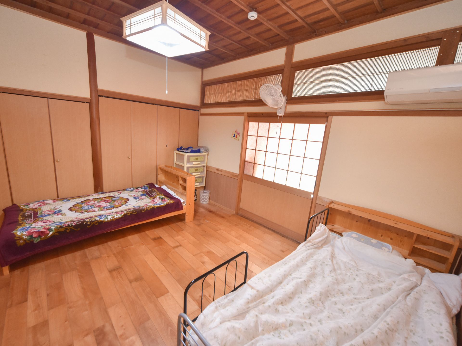 居室の中には2方向の壁際にそれぞれベッドが置かれている。右側のベッドには安全性に配慮されたフェンスが設置されている。