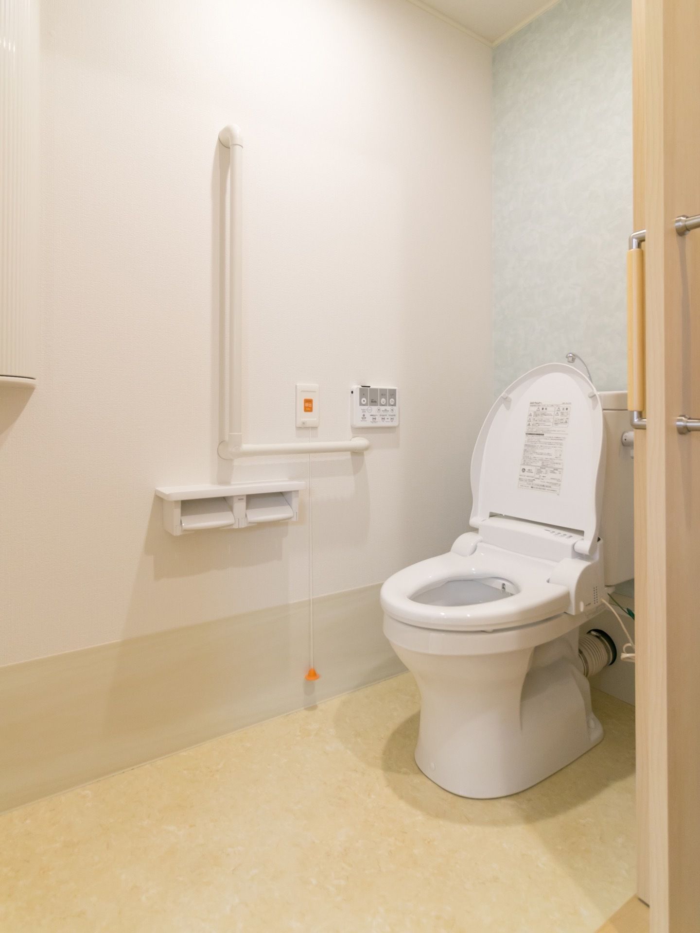 温水洗浄便座の洋式トイレを設置している。操作ボタンが壁に取り付けてあるので押しやすく使いやすい。壁には手すりがあり安全である。
