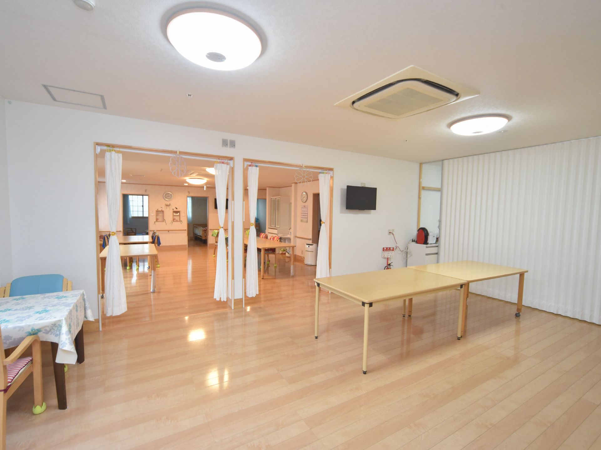 共有スペースのインテリアは白と明るいブラウンが中心となっている。テーブルの脚には部分的にキャスターが付いている。