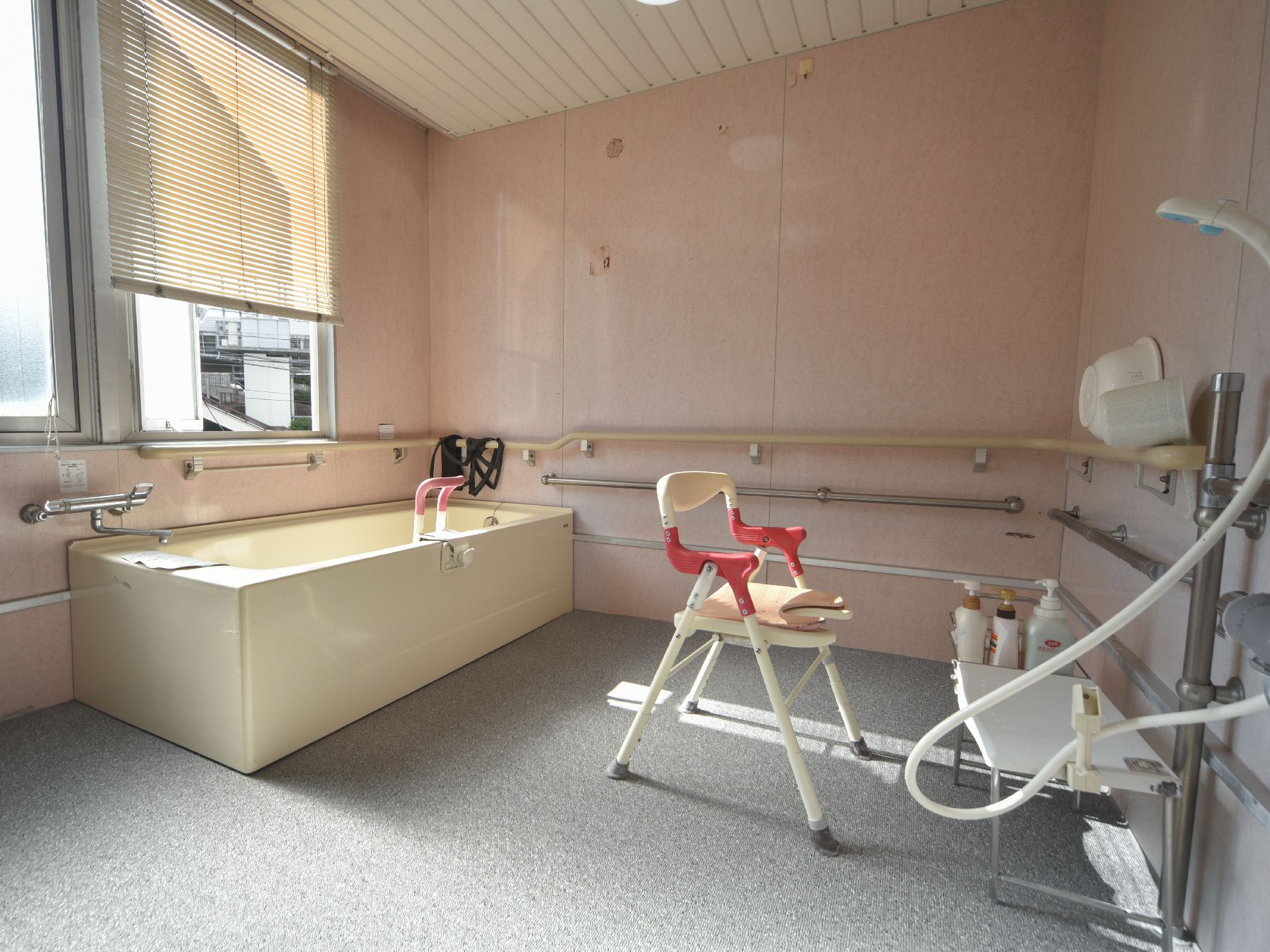 広々とした浴室には、安全面を考慮して壁に沿って横に手すりが取り付けられており、浴槽内にも高さ調節付き手すりが設置されている。