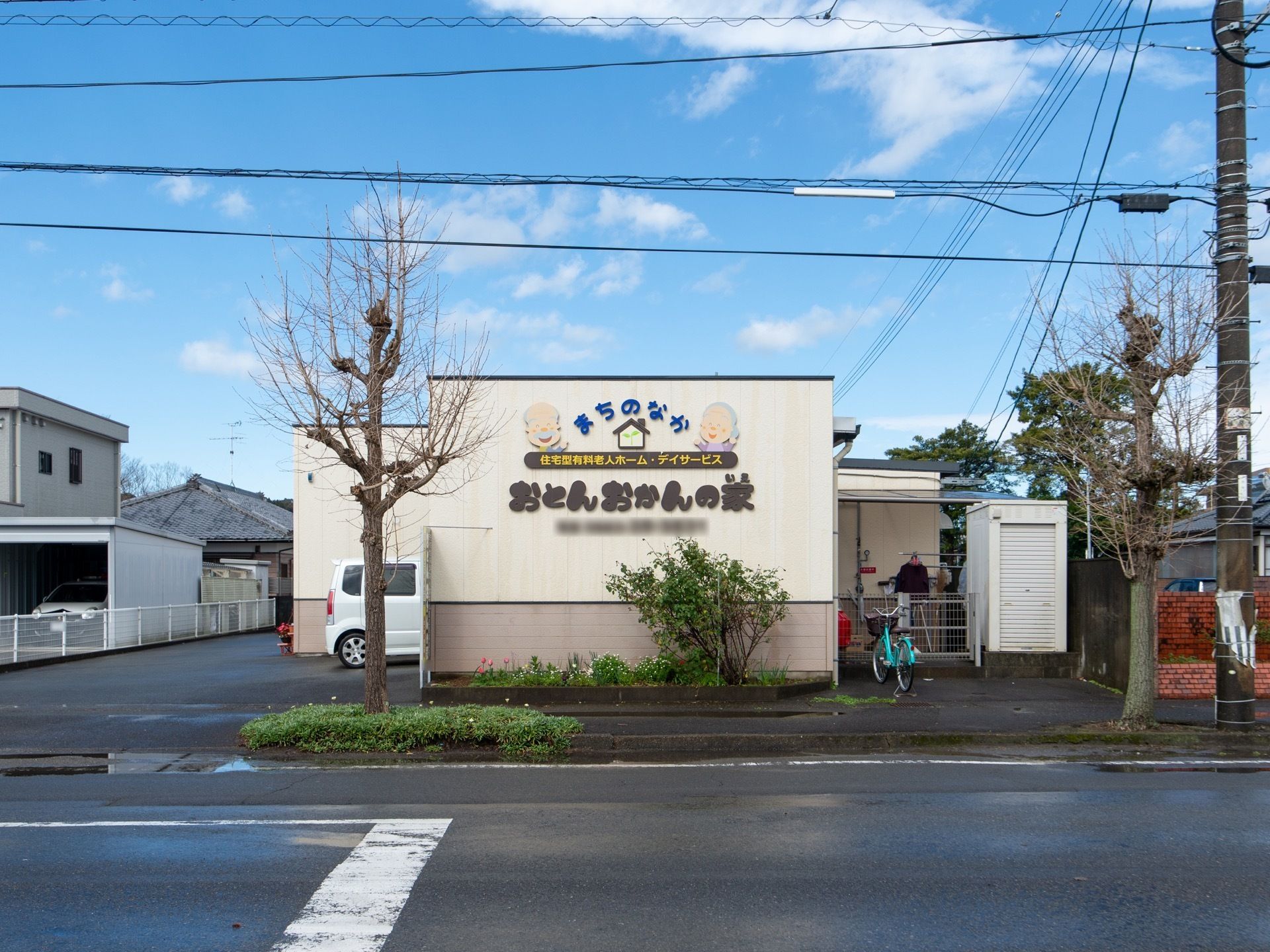 道路沿いの壁には施設名が表示されており、かわいらしいイラストも一緒に書かれている。壁の前には木々が植えられており、自然に親しむことができる。