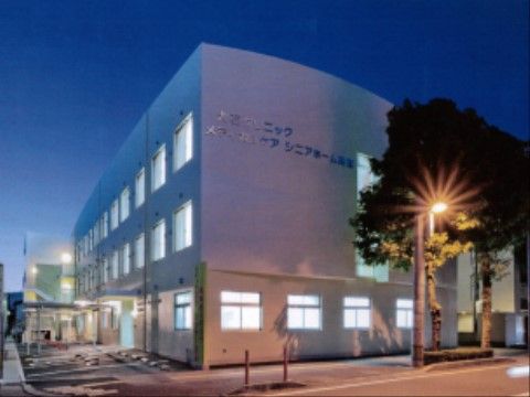 街中に立地し、駐車場も備わった三階建ての、外壁に大きく名称が書かれた施設