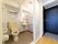 洋式トイレがある横の壁に緊急用ブザーが取り付けてある。予備のトイレットペーパーロールが棚にある。洗面所があり、カーテンで仕切っている。