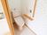 居室には個室のトイレが設けられている。左手側の壁には手すりや各種パネル、背中側にはタオルを掛けるためのバーがある。