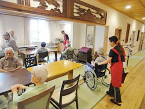 欄間のついた和室に車いすを押されて出入りする高齢者様