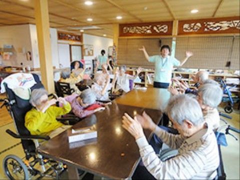 スタッフを中心にしてテーブルを囲んだ高齢者様が行うレクリエーション