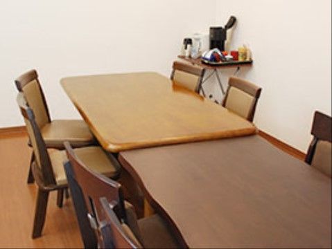 白い壁、木目調の床の部屋には色違いの高さの違う木製テーブルセットが並べて置かれ、隅にはポットなどのお茶のセットも置いある。