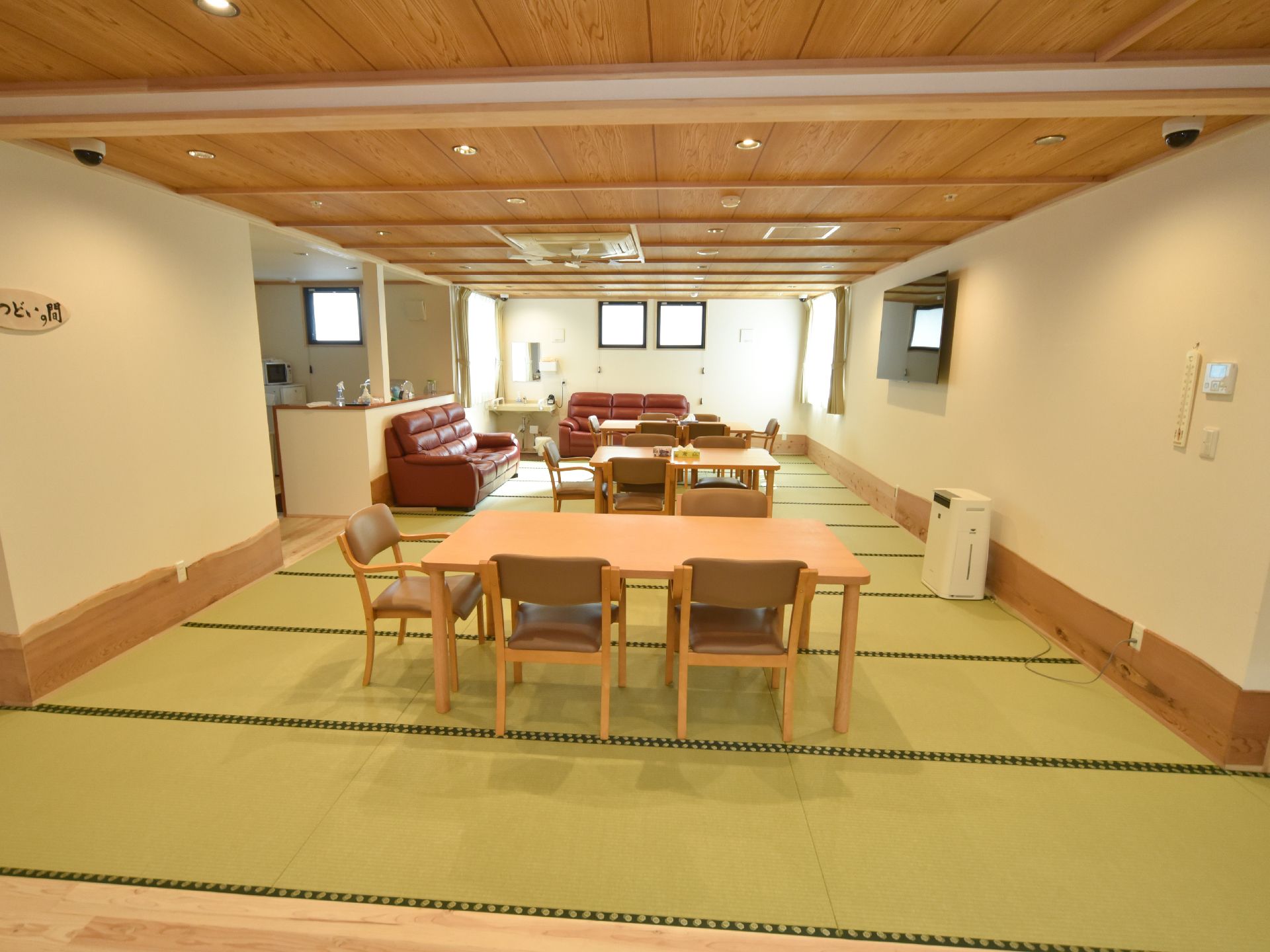 木製天井と畳敷きのところにダイニングテーブルとソファーを配置した、和モダンテイストな空間。窓が多くとても明るい。