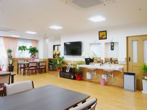 入居者様が気持ちよく過ごせるように観葉植物がたくさん置かれている他、椅子やテーブルを落ち着いた色でまとめている。