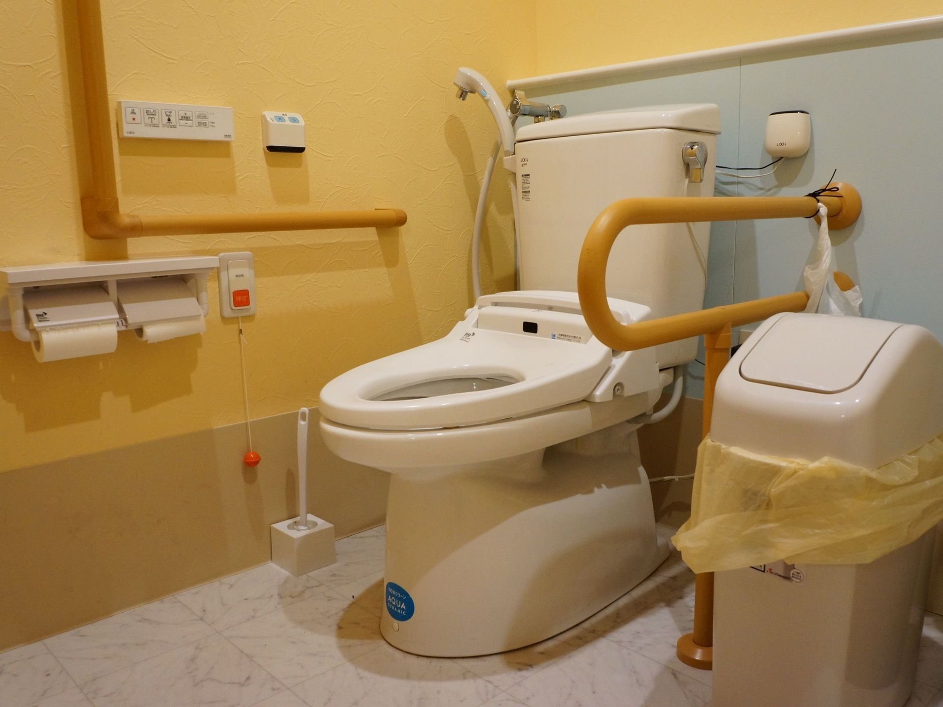 トイレには温水洗浄便座とシャワーを完備している。壁には手すりのほか、操作パネルとナースコールを設置している。