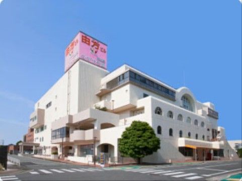 ６階建ての白い大きな建物は、所々に孤を描いて飛び出した部分がある個性的な形。道路に面した角地に建っている。