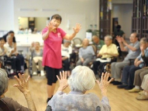 スタッフを囲んで体を動かすレクリエーションを行う入居者様達