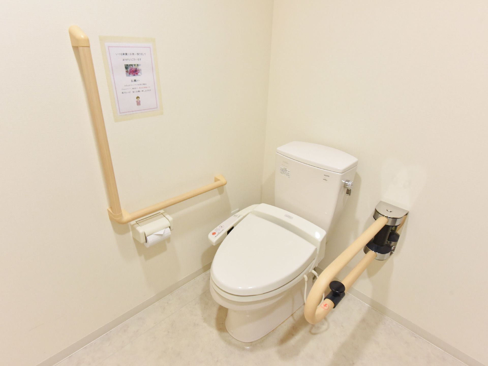 洋式トイレの便座の両側に、手すりが設置されている。左側の手すりは使いやすいように可動式になっている。