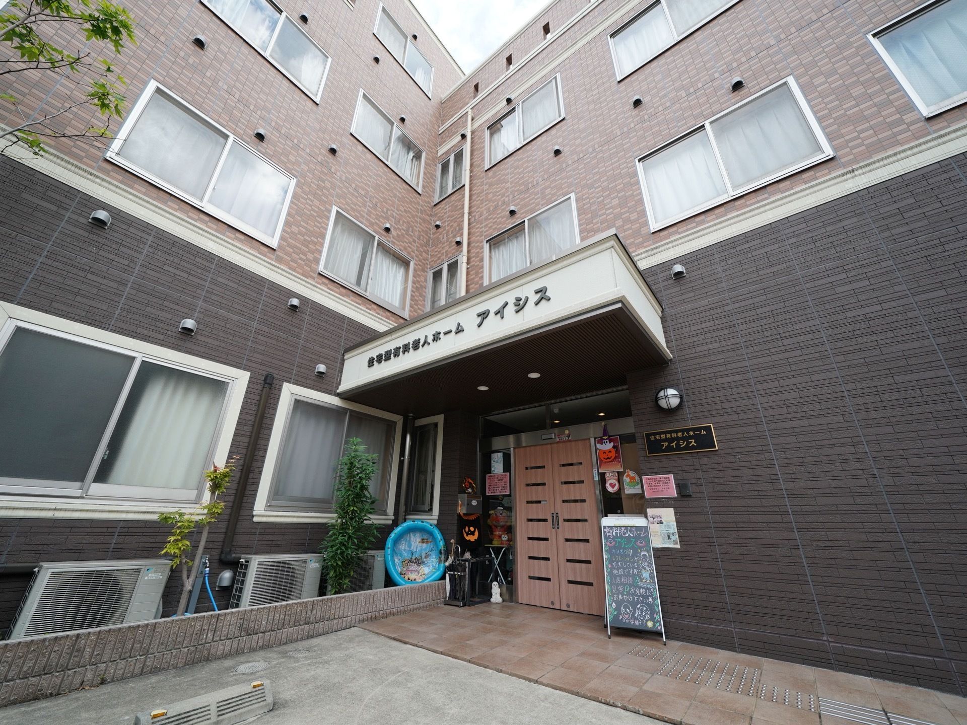 施設は閑静な住宅街に建てられている。駐車スペースを挟んで建物がL字型。敷地内はすべてバリアフリーになっている。