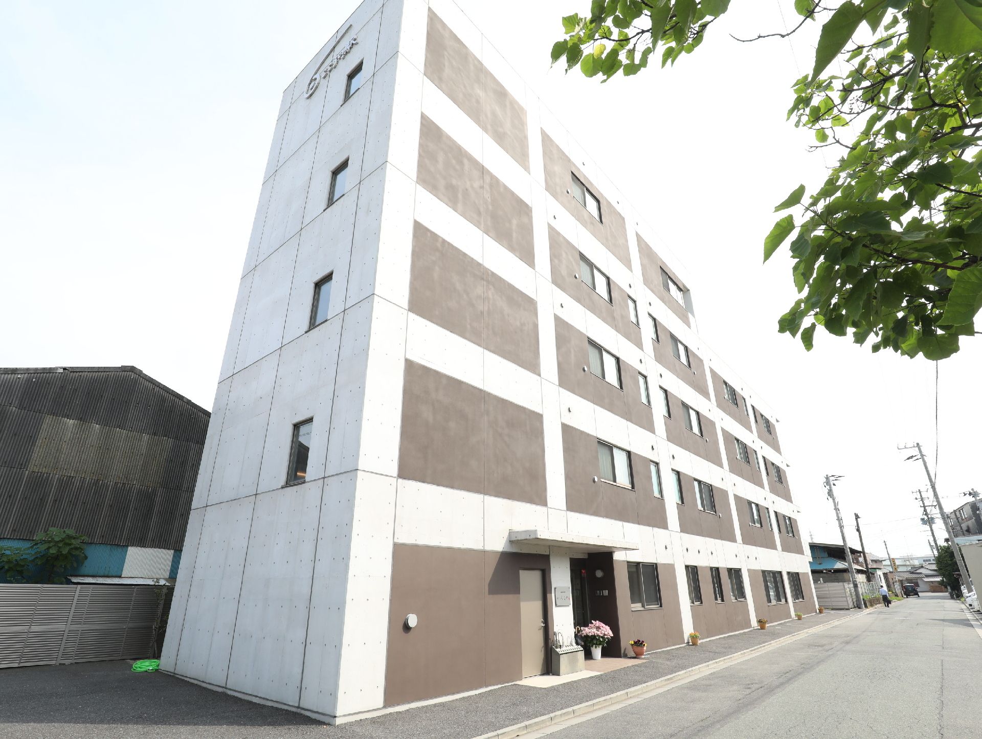 コンクリート打ちっぱなしのお洒落な外観の、四階建ての施設