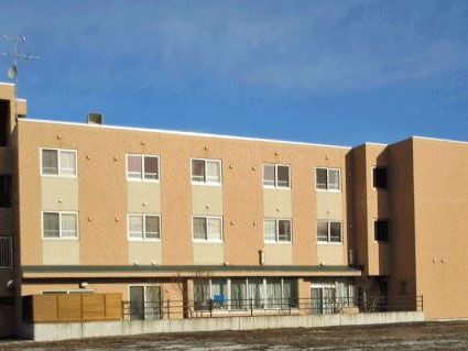落ち着いたブラウン色の壁の施設。窓が設置されており、開放感がある。安全のため、フェンスも施設の周囲に完備されている。
