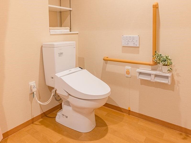 広い介助スペースがあるトイレには手すりや呼び出しボタンも設置されている。