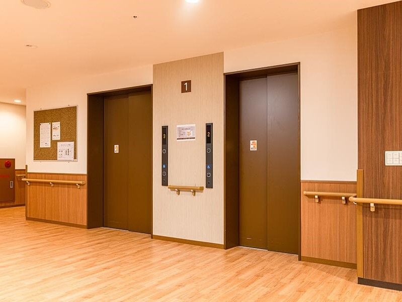 2基のエレベーターが設置された場所。ホールには何も置かれておらず、壁には手すりが付いている。
