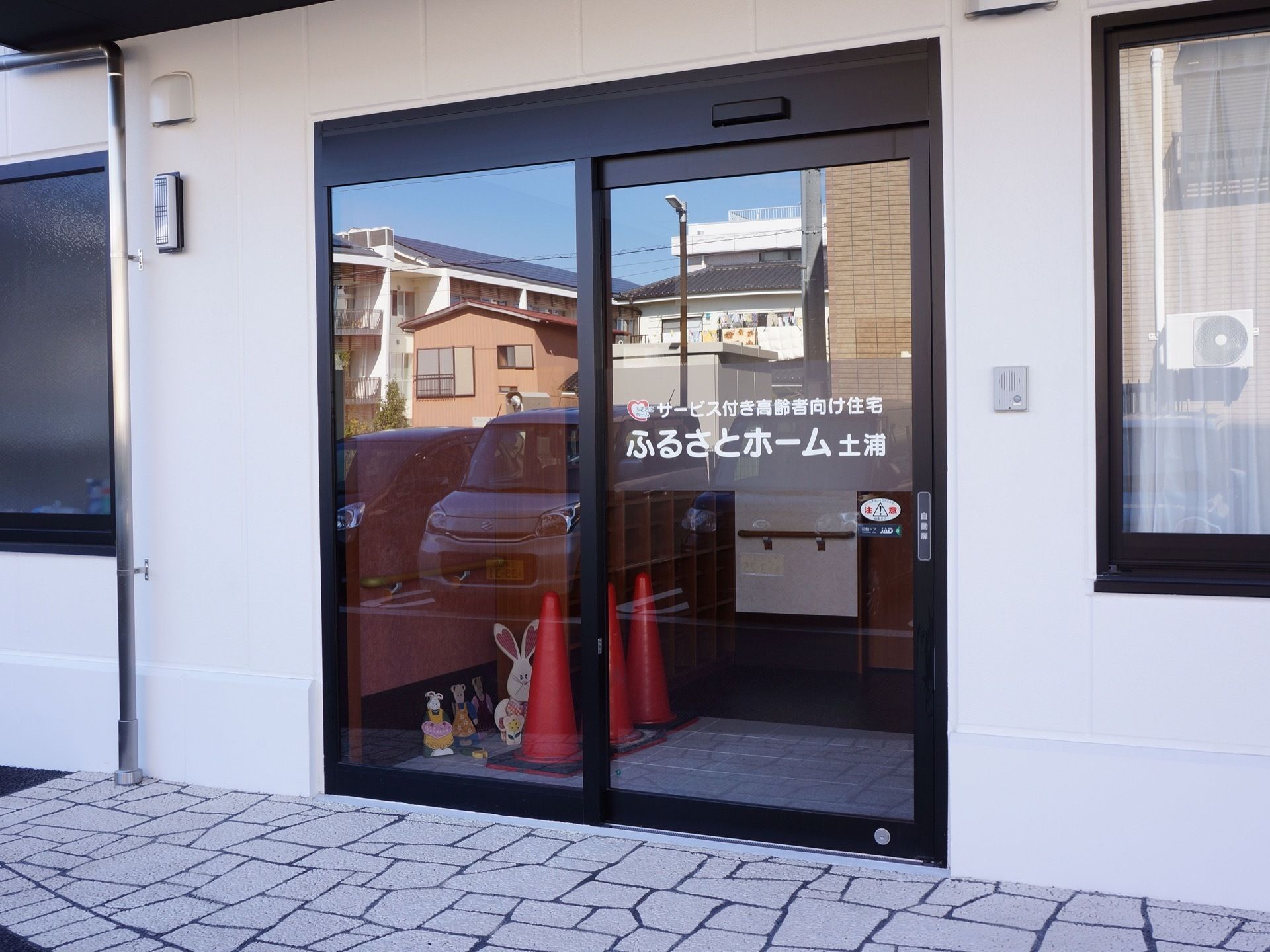 施設入口は自動ドアになっていて、壁にはインターホンが取り付けられている。玄関周りは段差のないバリアフリー設計である。