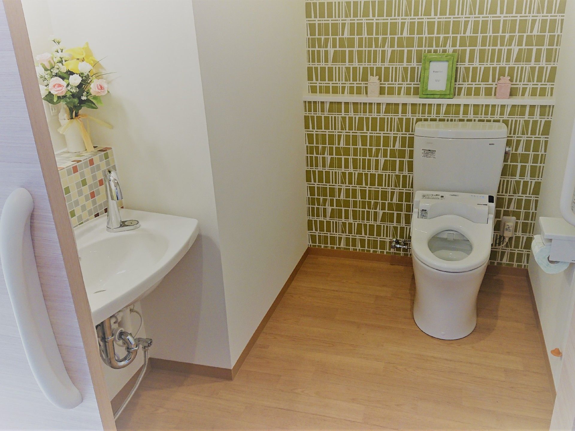 洗面台のタイルや壁紙、花の装飾などで明るく優しい雰囲気のトイレは十分なスペースがあり、車椅子をご利用の方に快適にご利用いただける。