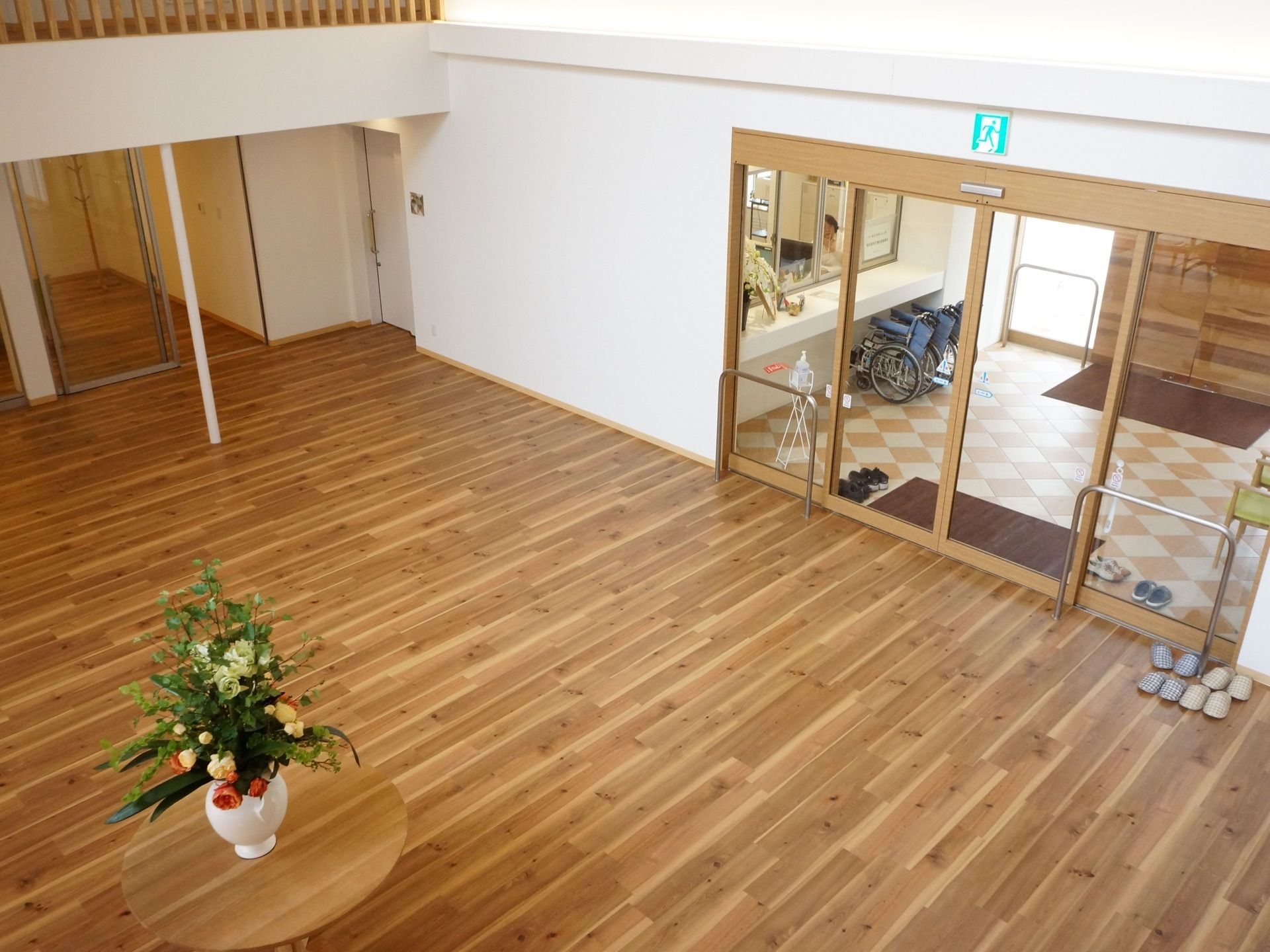入口の扉は大きな両開きの自動ドア。ドアが透明で、出入りの際に中と外の入居者様がぶつかる心配がない。建物の中は自然光で明るい。