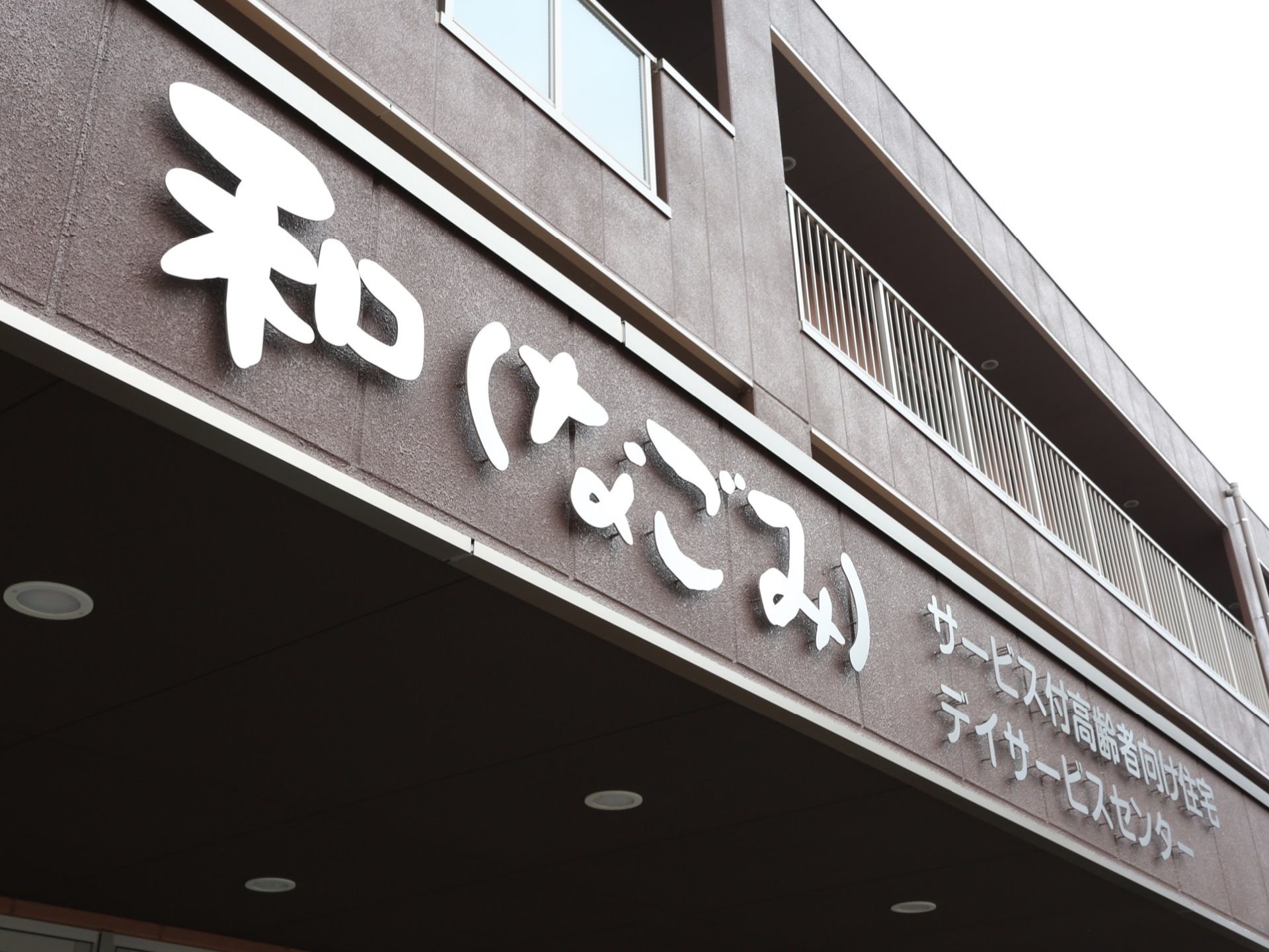 玄関上の壁部分に、字が浮き出た感じで施設名称とサービス区分が示されている。立体的で見やすくなっている。