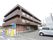 広い敷地に建つ施設である。裏側の敷地は貸駐車場となっており、玄関脇には入退管理の設備が設置されている。