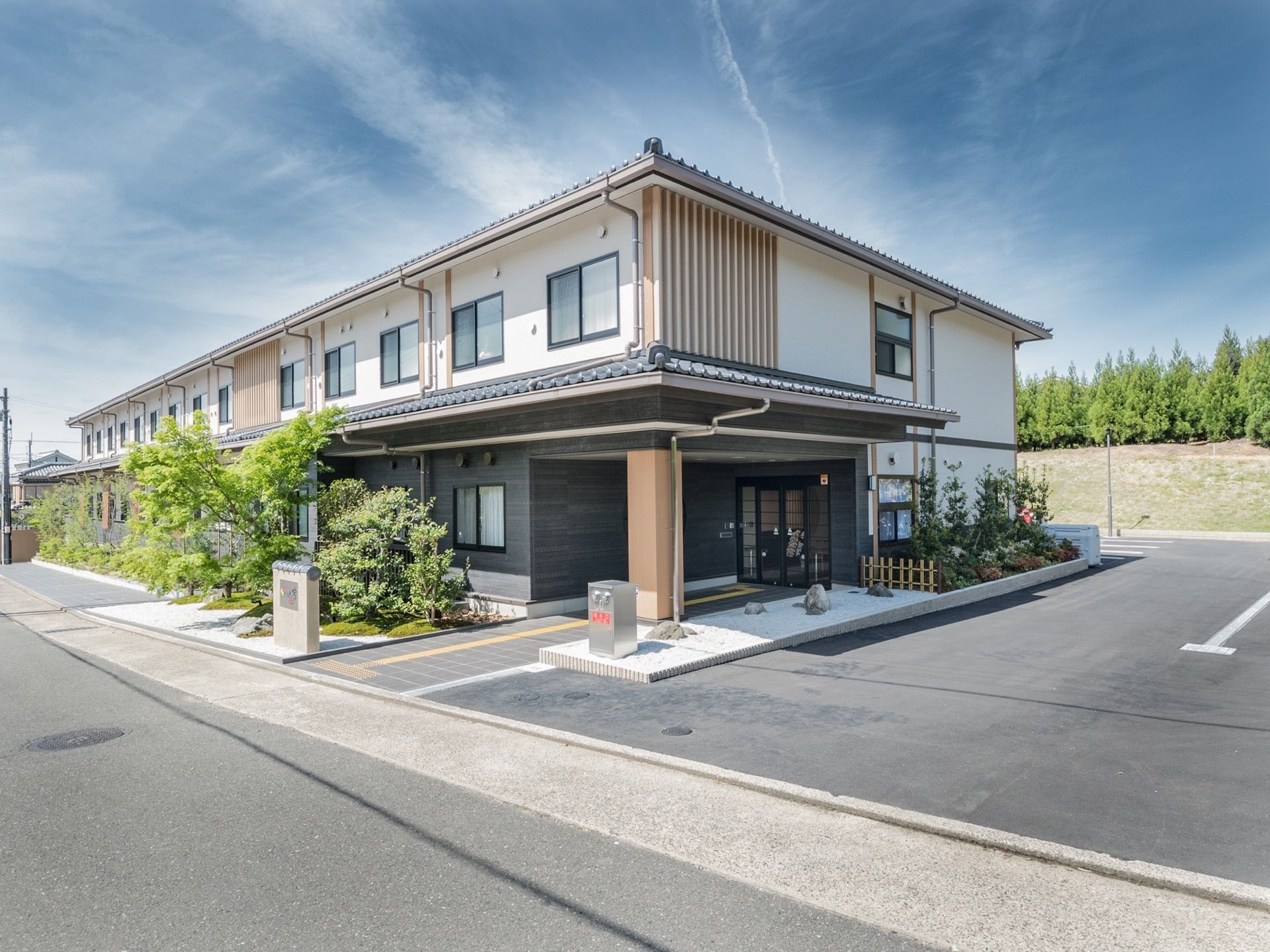 施設は瓦屋根の和風の作りをしており、ご年配の方にも馴染みのある設計となっている。駐車場もあるため自家用車の利用も簡便に行える。