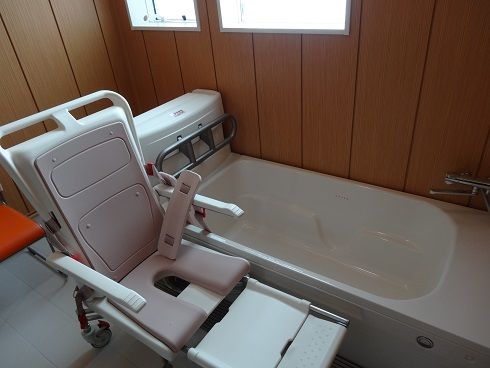 介護浴槽と特殊な椅子が置かれており、寝たままや座ったままの姿勢で入浴することができる。浴室は白い床と木目調の壁が落ち着く雰囲気となっている。