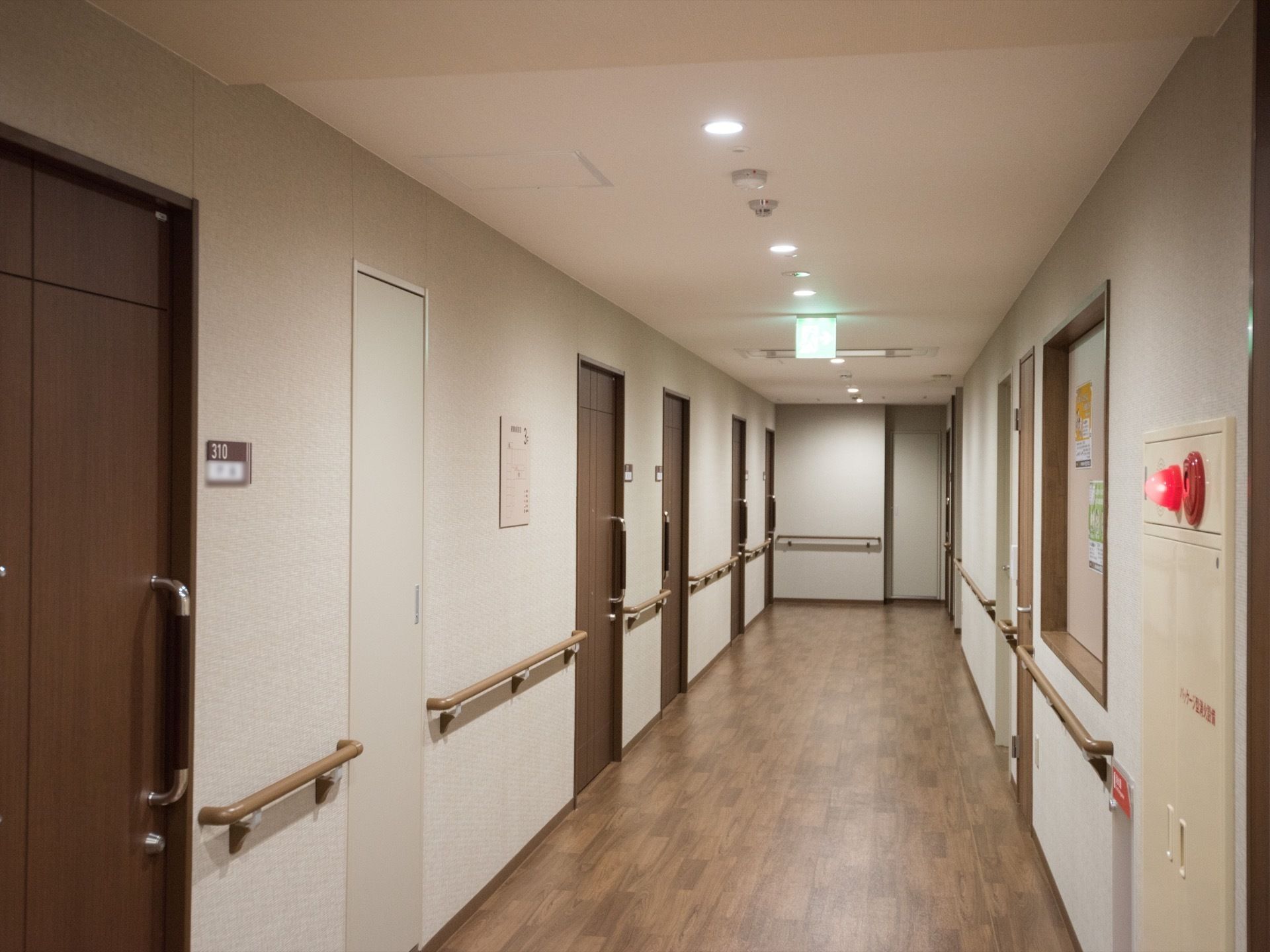 モダンな雰囲気の施設廊下である。統一感があり、ホテルを思わせる空間である。床に物を置かず、整理整頓されている。