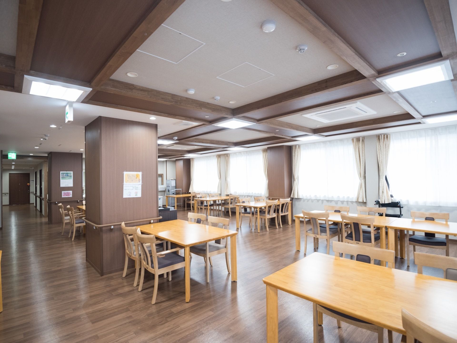 モダンな折上げ天井を採用し、広々として開放的な食堂である。複数設けられた窓から明るい光が差し込んでいる。