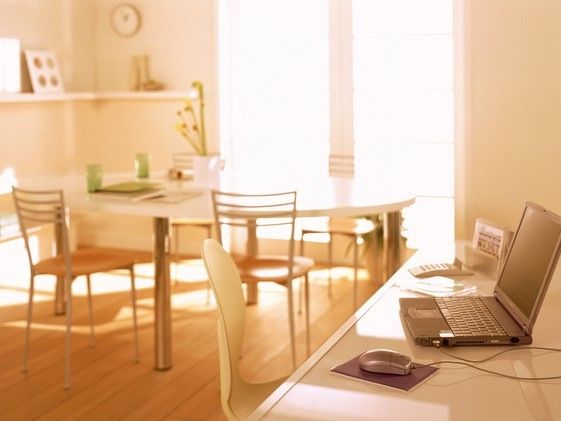 白を基調とした明るい日差しの入る居室。テーブルセットとテスクが設置されている。デスクの上にはパソコンがある。