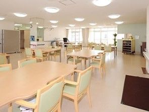 20人以上がゆとりを持って利用できる広い食堂である。横長の4人掛けテーブルと、天井には丸いシーリングライトが並んでいる。