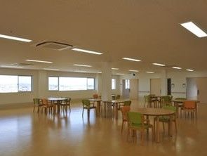丸いテーブルに緑やオレンジの椅子が備えられている。とても広いスペースになっており、車椅子をご利用の方でも移動が楽に行える。