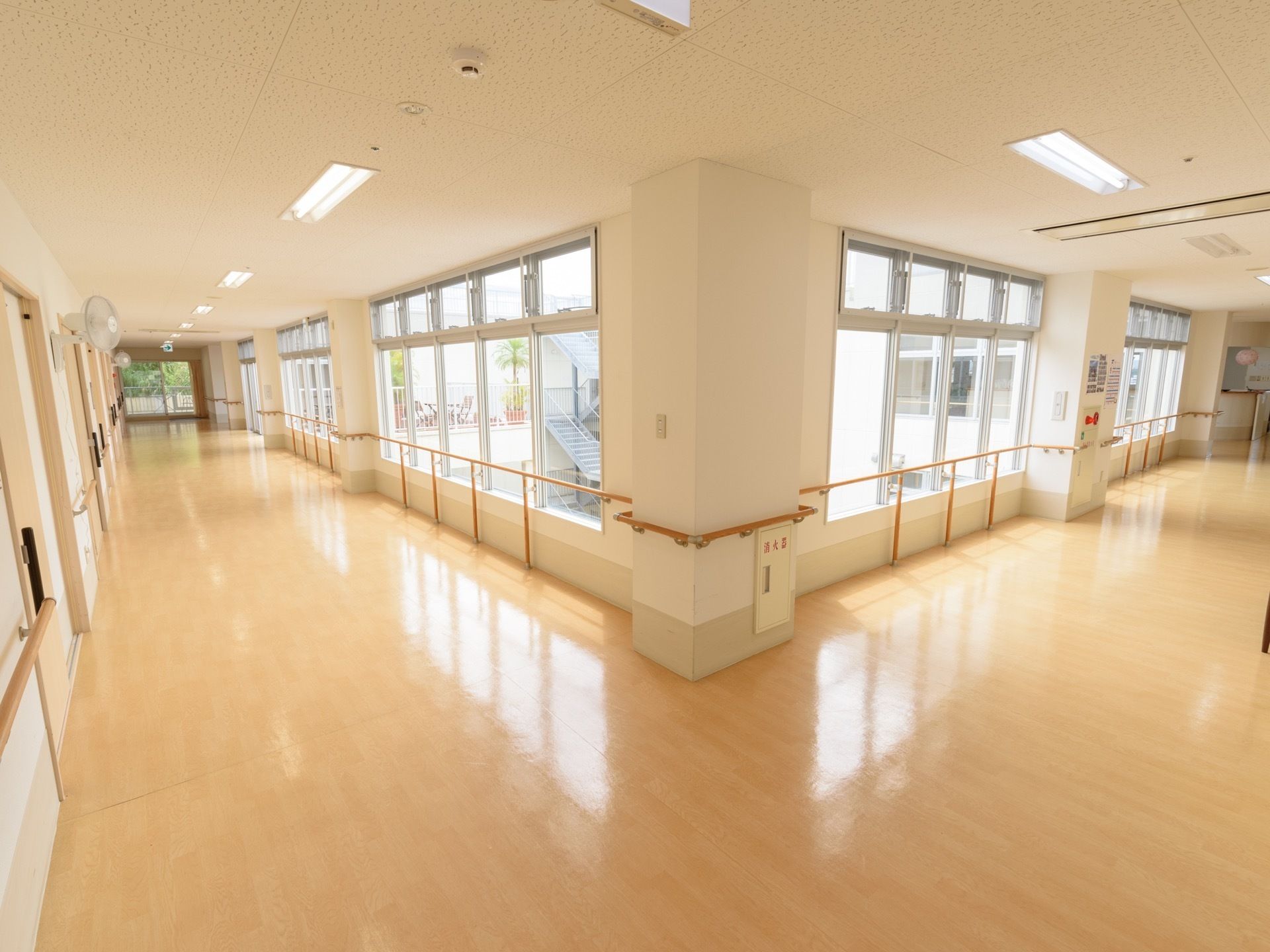 廊下は窓が張り巡らされ、とても明るい。両サイドの壁には手すりが取り付けてあり、安全に通行することができる。