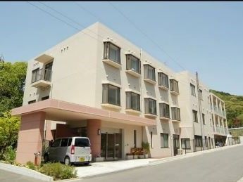 白い出窓が並び、エントランスには茶色の庇のついた、三階建ての施設