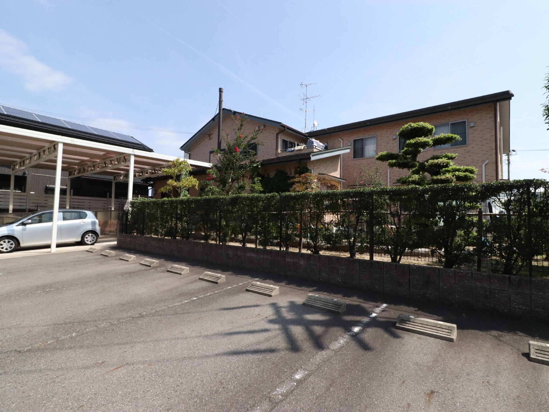 施設はレンガ調の建物である。近くには10台ほどの車が止められる場所とカーポート付きの駐車スペースがある。