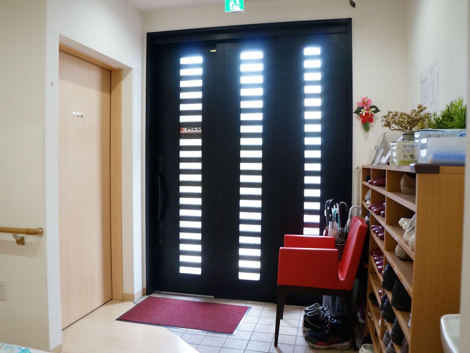 施設の出入口は黒色で間口が大きくスリッドになった小窓がついているため、十分な採光を確保することが可能である。
